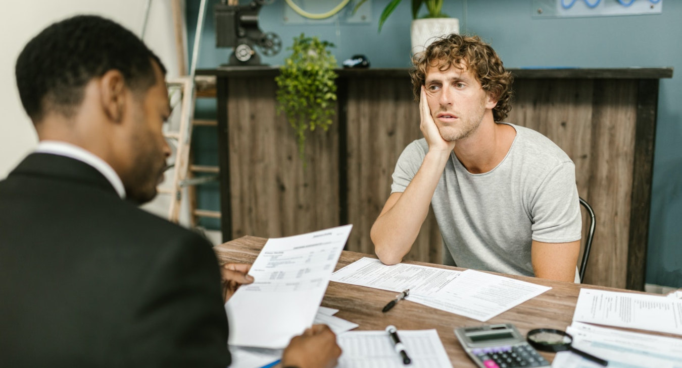 Man sitting at desk getting Debt Management advisory